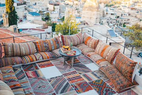 Terraza cubierta de cojines, alfombra y sofá