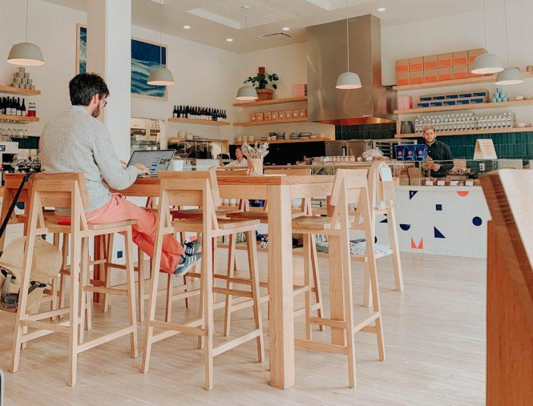 man sitting on brown wooden chair beside table